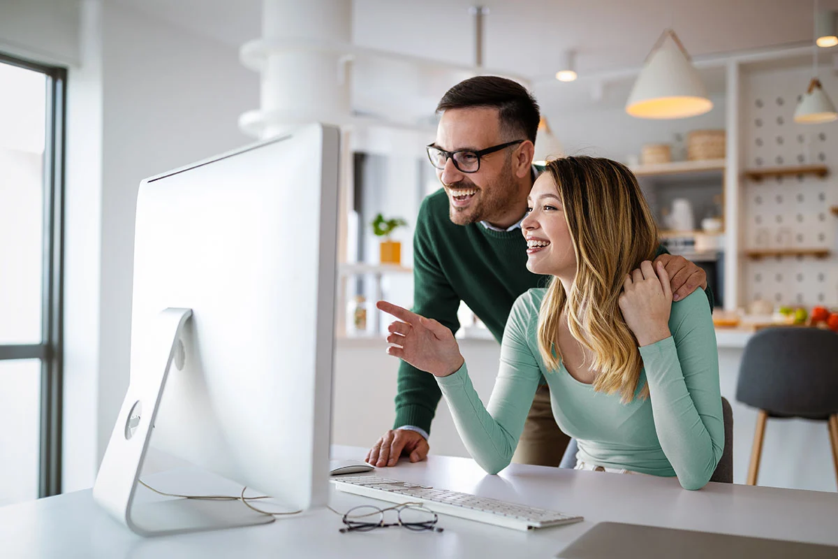 Couple smiling at their computer